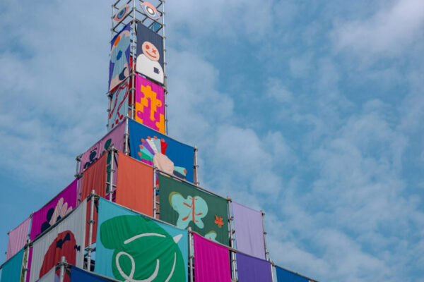 Colourful banners attached to a metal scaffolding pyramid structure