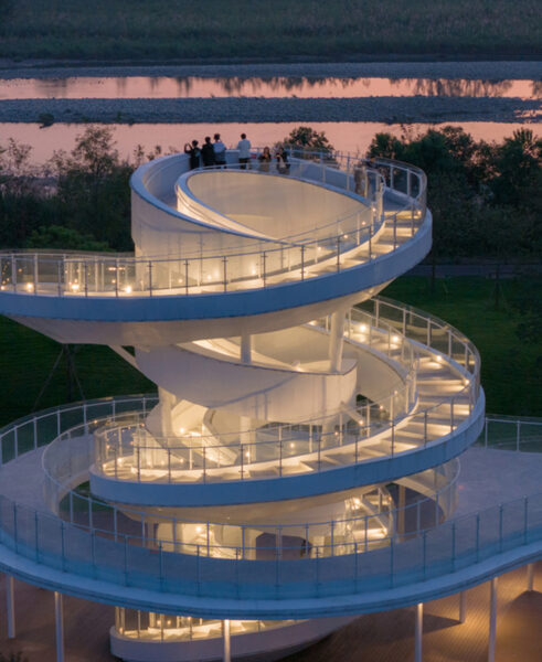 A winding set of stairs is part of a beautiful architectural white building.