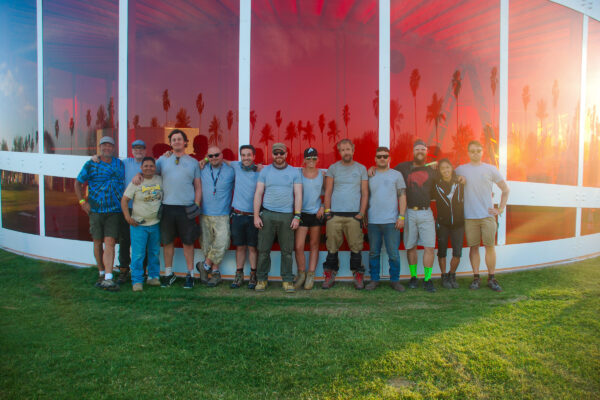 Team stand in front of rainbow coloured spectra installation