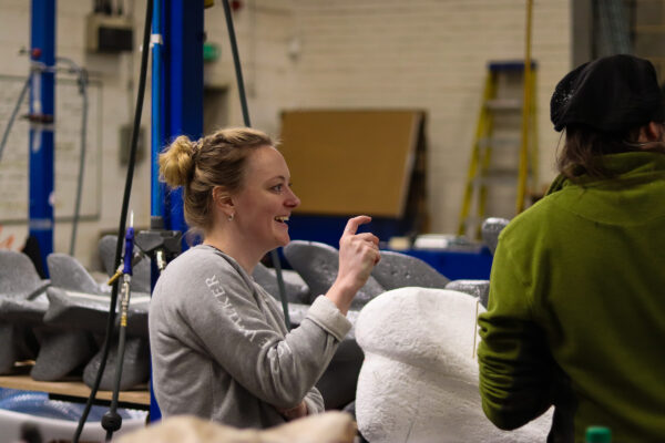 Team member smiles and points in the workshop