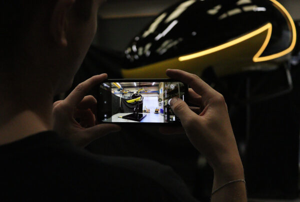 Somebody taking a photo on their phone of the final flying taxi installation in a workshop.