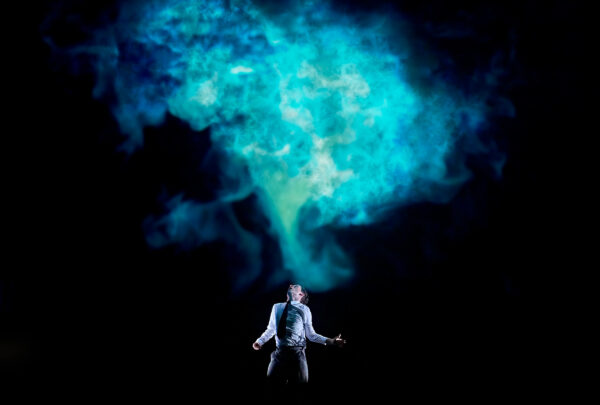 Blue smoke cloud with a man below it.