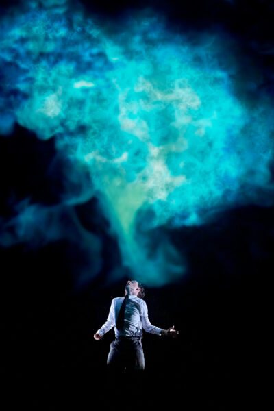 Blue smoke cloud with a man below it.
