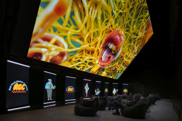 Large screen on a ceiling with people sat below it looking up.