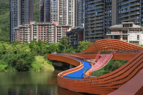 Winding orange bridge design over a river.