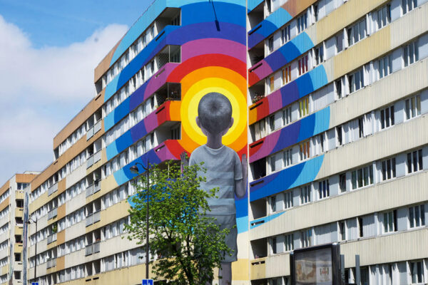 A painted art mural on the side of a block of flats.