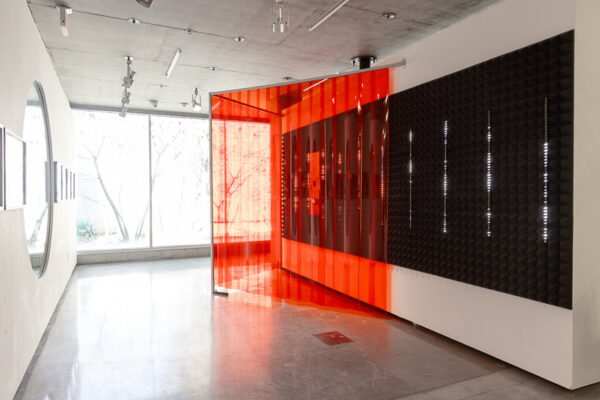 Inside exhibition space with orange booth in the middle.