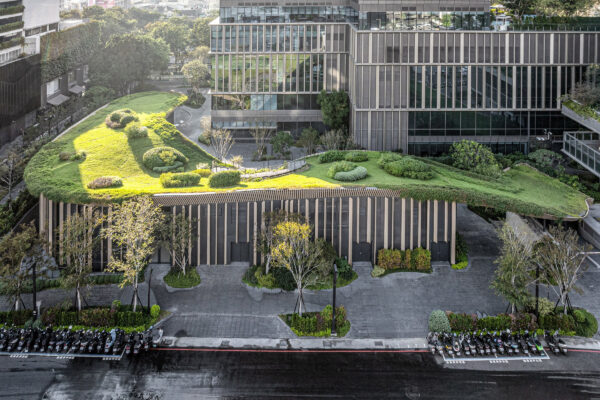 A new building with a luscious green rooftop complete with trees and grass