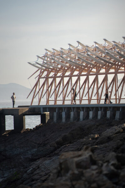 Wooden kinetic installation on the rocks by the ocean